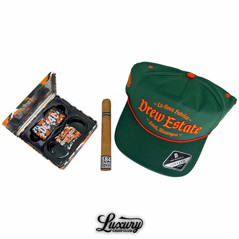 Liga Privada Black Friday 2025 Freebie Sampler No 2 freebies including Drew Estate hat camo tin and S84 Shade to Black cigar presented by Luxury Cigar Club
