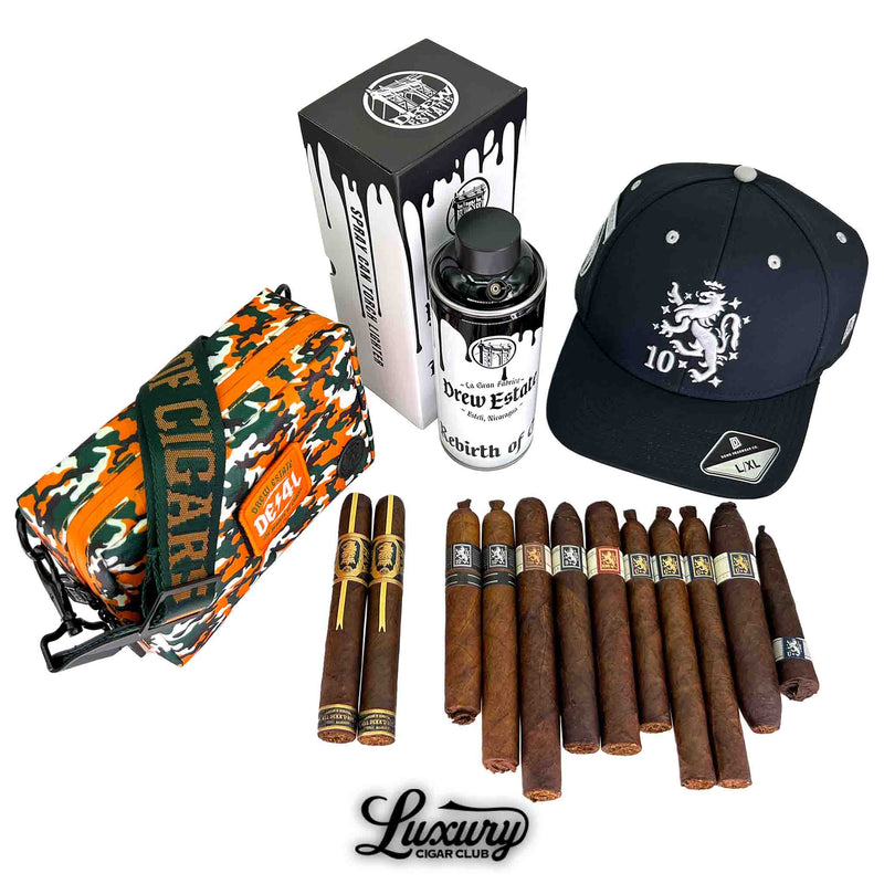Luxury Cigar Club product image showcasing the Liga Privada Black Friday 2025 Freebie Sampler No 3 with a full sampler spread including Drew Estate cigars, a DE4L camo bag, a Drew Estate spray can humidor, and a black 10th anniversary hat arranged together.
