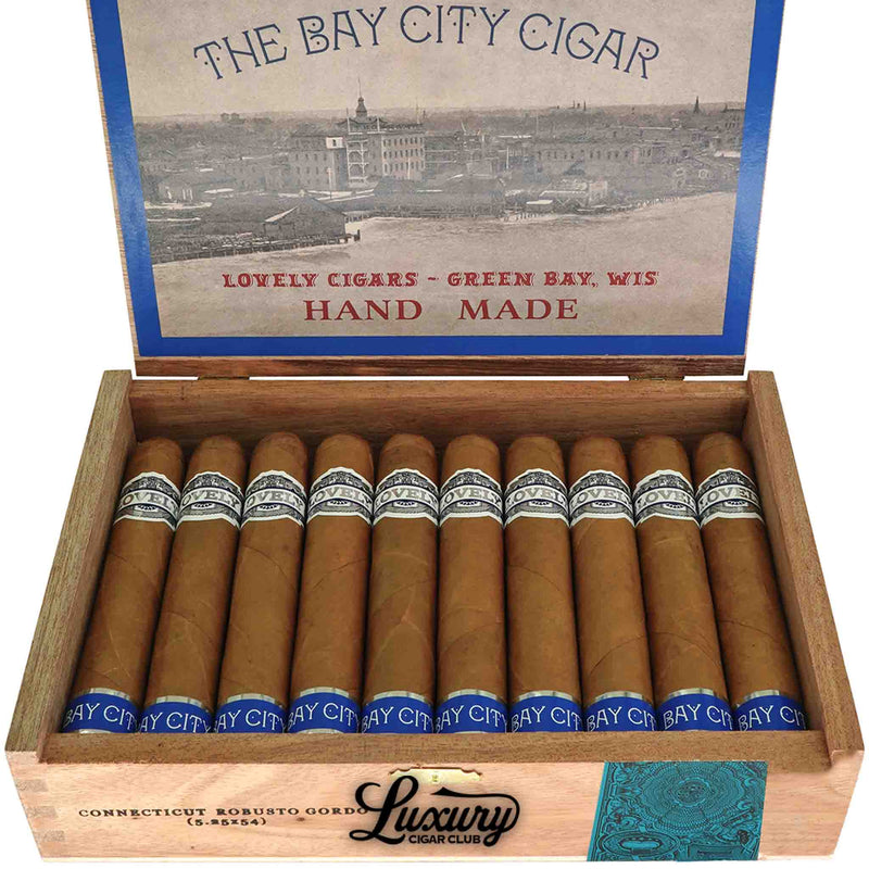 Close-up of Lovely Cigars The Bay City Cigar Connecticut Robusto cigars arranged neatly inside a wooden box. Each cigar displays silver and blue bands, and the box lid showcases Green Bay-themed vintage art. Luxury Cigar Club logo beneath.