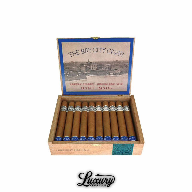 Open box of Lovely Cigars The Bay City Cigar Connecticut Toro cigars with Connecticut shade wrappers and blue-silver branding. The interior lid features “The Bay City Cigar” and “Lovely Cigars – Green Bay, Wis” design. Luxury Cigar Club logo below.
