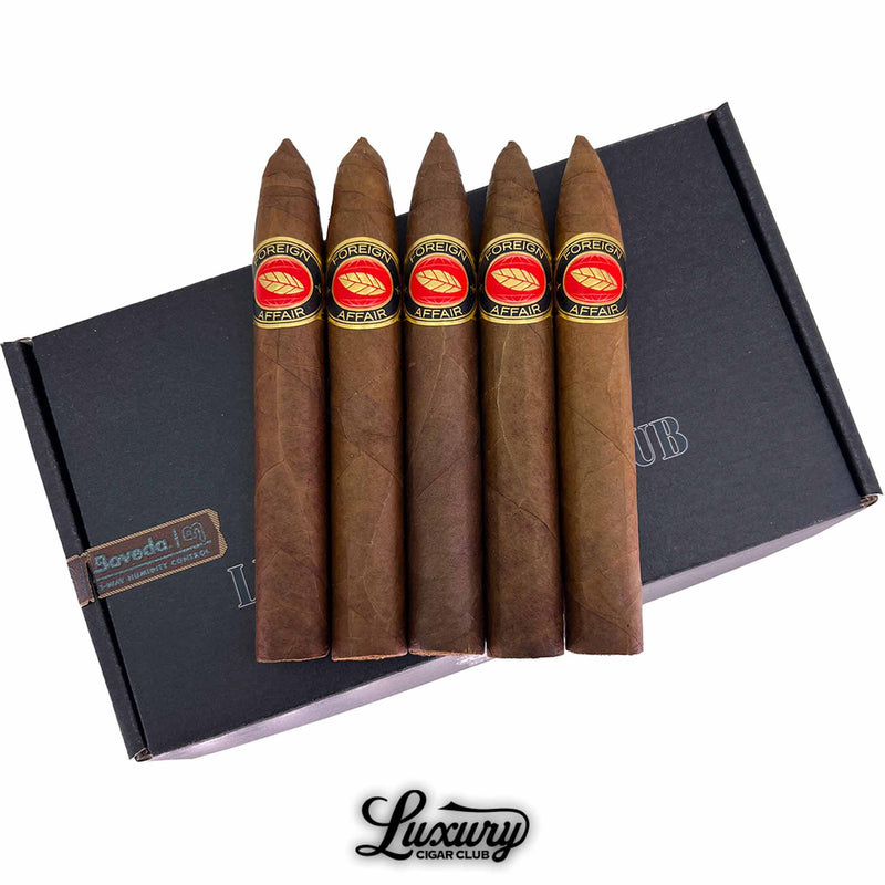 Close-up of Luciano Foreign Affair cigars with red and gold bands arranged on a Luxury Cigar Club black box, showcasing premium hand-rolled torpedo cigars for sale online.