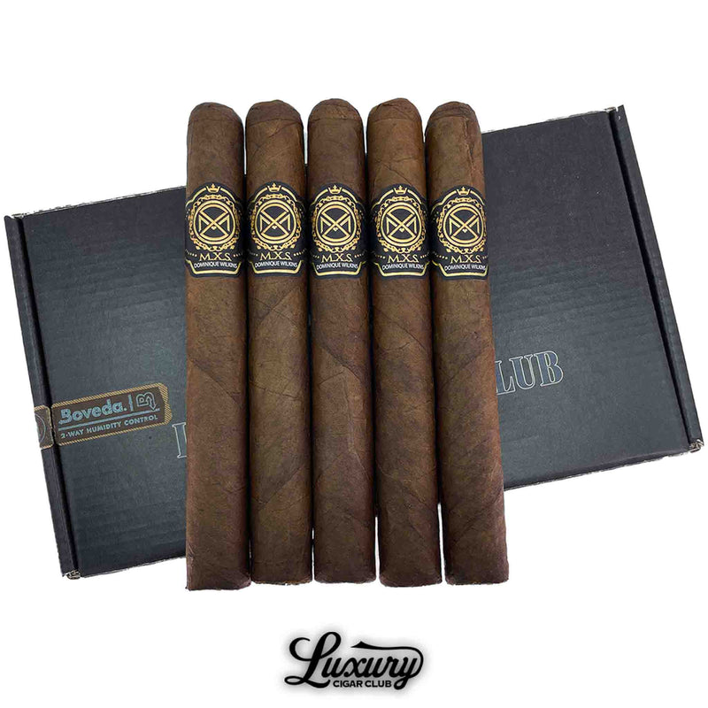Close-up of Luciano MXS Signature Dominique Wilkins cigars with dark brown wrappers and black and gold bands, displayed in front of a black Luxury Cigar Club box with Boveda humidity control.