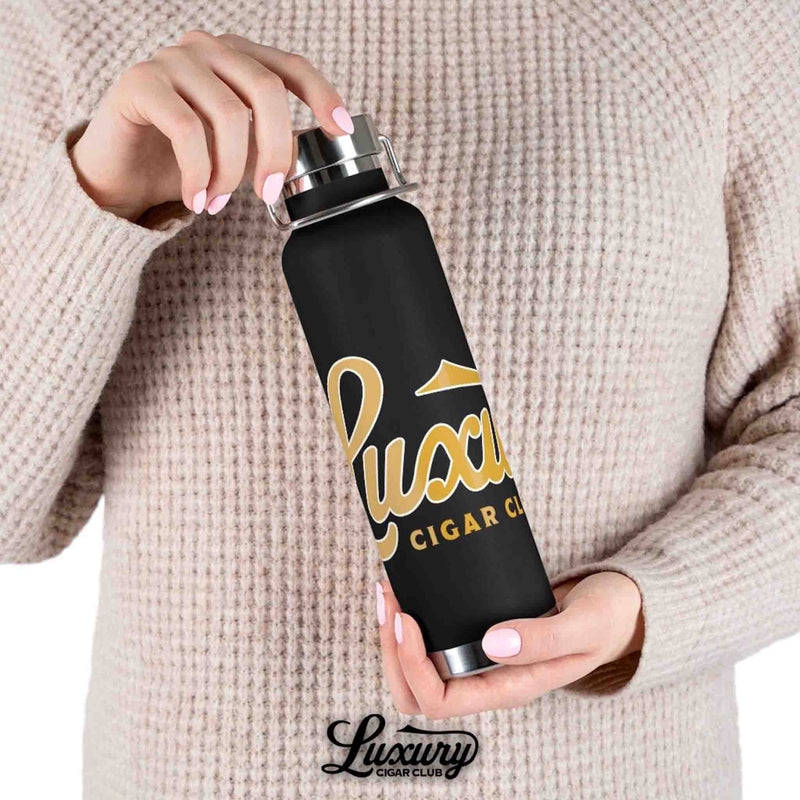 woman holding luxury cigar club copper vacuum 22oz insulated bottle black with gold logo