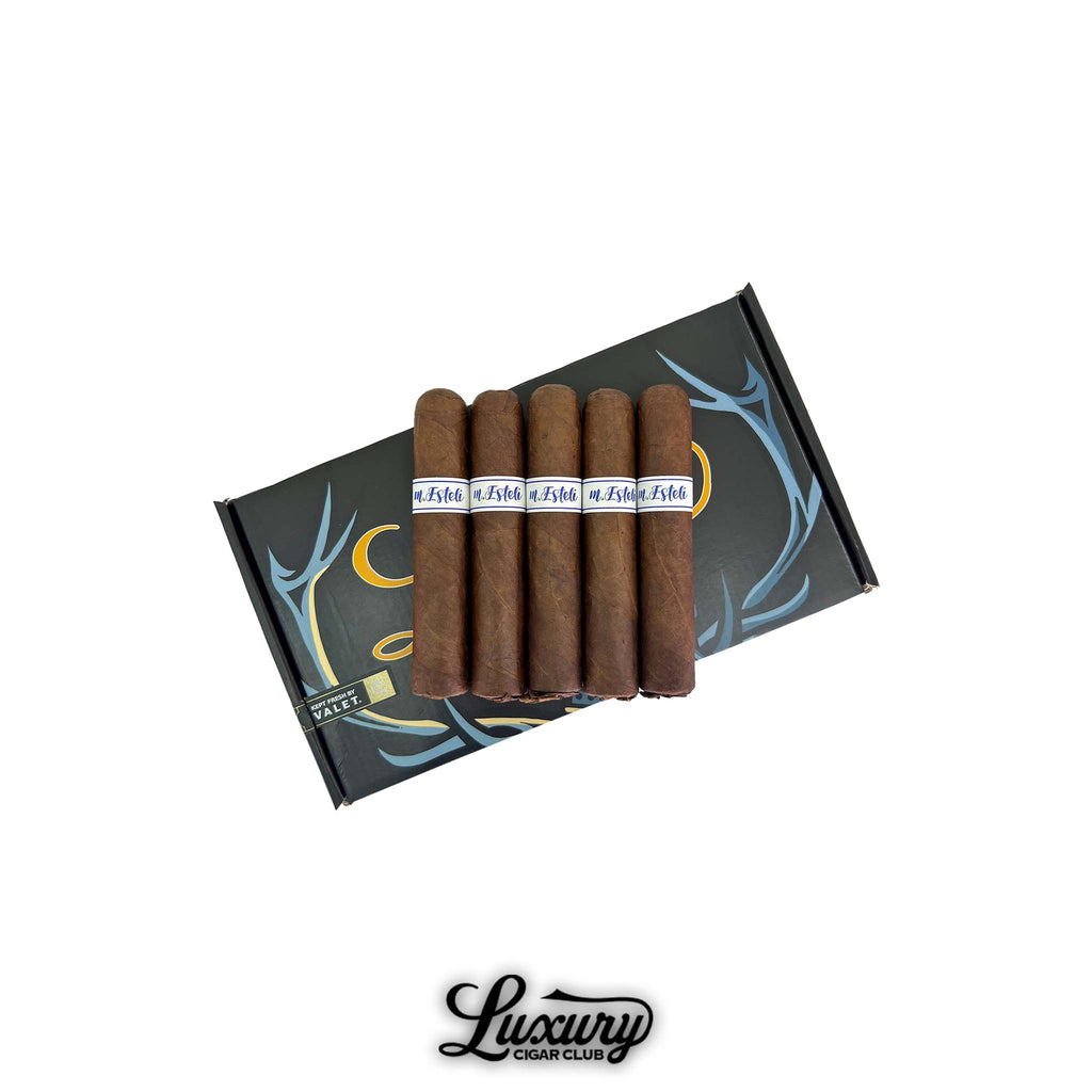 MBombay M.Esteli Robusto cigars displayed on a sleek black and blue box with elegant branding, presented by Luxury Cigar Club.
