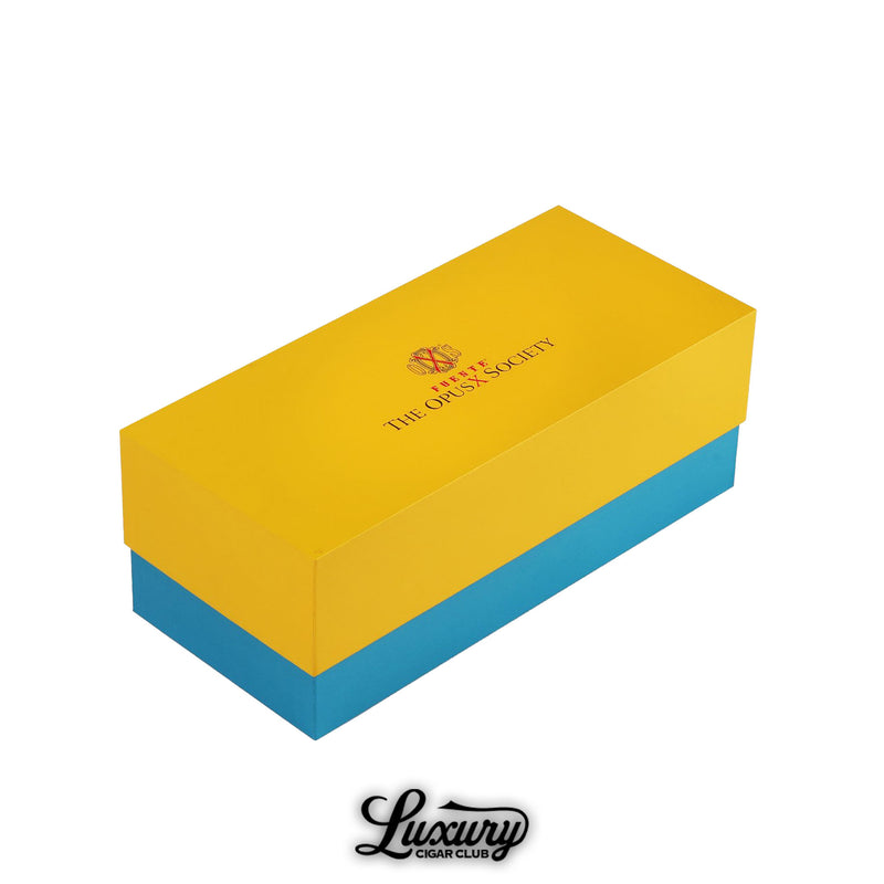 Yellow and blue Manny Iriarte Opus X Society whiskey glass gift box with signature branding, available at Luxury Cigar Club.