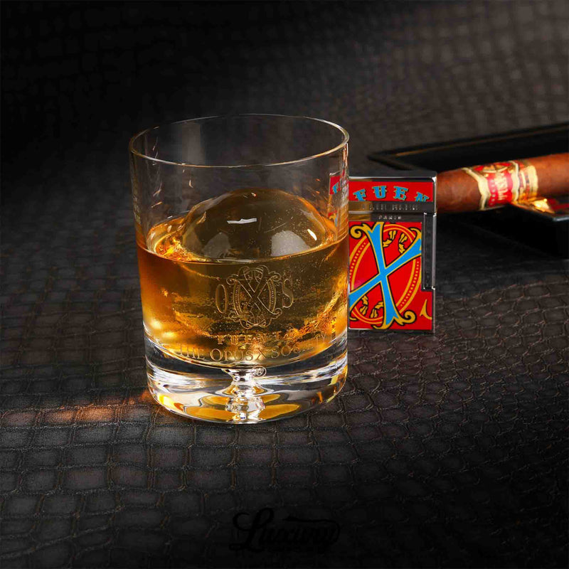 Opus X Society whiskey glass filled with bourbon, paired with Arturo Fuente cigar and accessories, exclusive from Luxury Cigar Club.