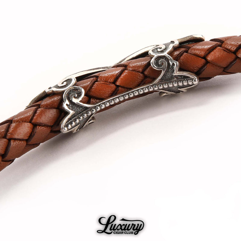 Close-up of Manny Iriarte Opus X Society camel leather bracelet with woven design and ornate silver detailing, available at Luxury Cigar Club.