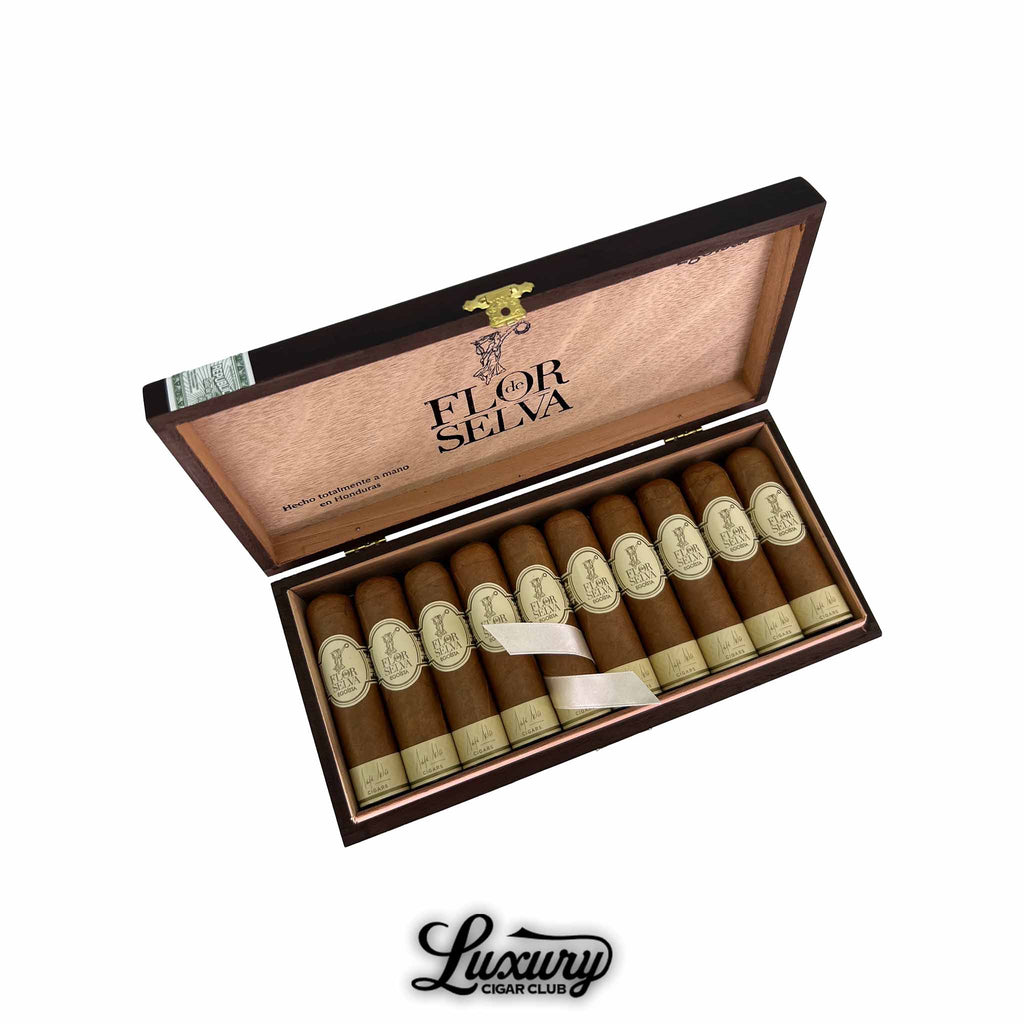 Open wooden box of Maya Selva Flor de Selva Classic Egoísta cigars handmade in Honduras, featuring ten short cigars with light brown wrappers and cream bands. Luxury Cigar Club logo displayed below.