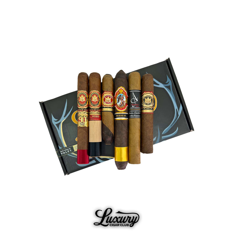 Luxury Cigar Club Opus and Prometheus Prestige Sampler shown on a black Prometheus box featuring six rare premium cigars including OpusX and God of Fire selections arranged neatly for an elegant high end presentation.