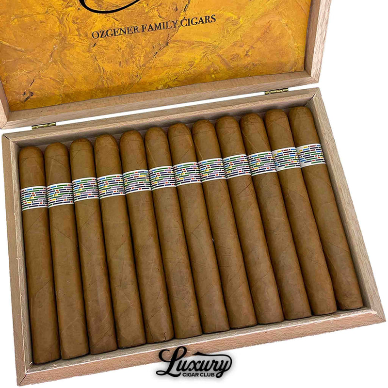 Close-up of Ozgener Family Cigars Pi Synesthesia Limited Edition Toro cigars inside an open wooden box, highlighting the smooth golden-brown wrappers and distinctive multicolored mosaic bands. The lid displays the Ozgener Family Cigars insignia on a marbled yellow background, representing craftsmanship and creativity. Luxury Cigar Club.