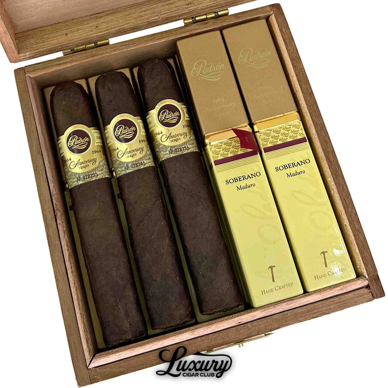 Close-up of Padron 1964 Anniversary Series Maduro Soberano tubos and cigars displayed together in a wooden box. Dark Maduro cigars and gold tubos emphasize premium craftsmanship. Luxury Cigar Club branding beneath.