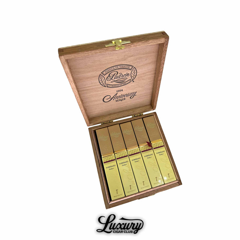Open wooden box of Padron 1964 Anniversary Series Soberano Maduro cigars in elegant gold tubos with embossed script, arranged in a cedar box featuring the Padron Anniversary logo on the lid. Luxury Cigar Club branding beneath.