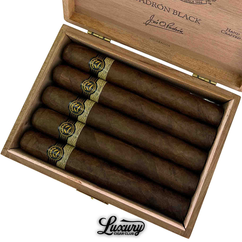 Detailed close-up of Padron Black Maduro Unicorn PB99 cigars with dark maduro wrapper and gold-black bands inside wooden box, Luxury Cigar Club logo at bottom.