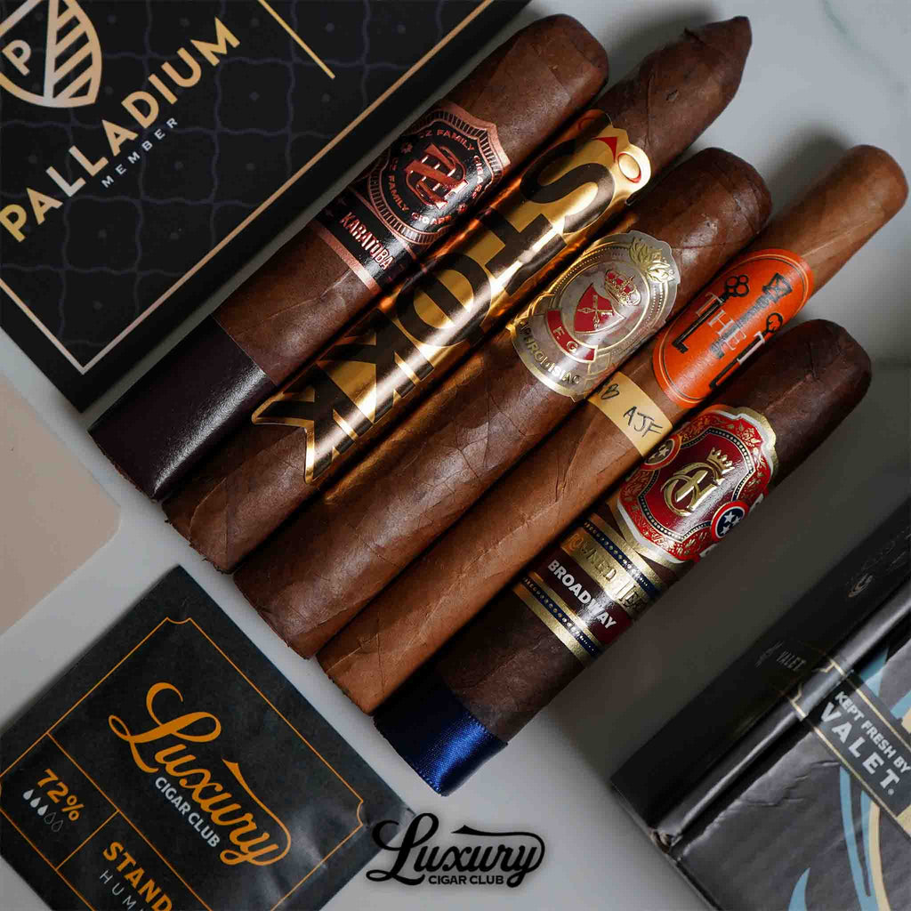 Premium cigar selection from Luxury Cigar Club’s Palladium membership, featuring five hand-rolled cigars with ornate bands, displayed alongside a 72% humidity pack and branded packaging.