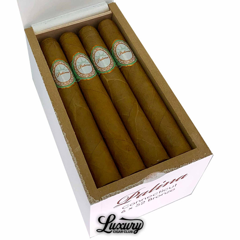 Close-up of Patina Connecticut Bronze cigars inside an open white box, showcasing the flawless Connecticut wrappers and refined Patina bands, presented by Luxury Cigar Club.