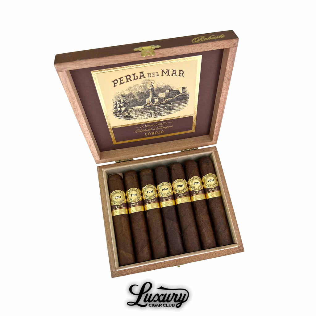 Perla Del Mar Corojo Robusto cigars displayed in an open wooden box with gold detailing showing seven cigars arranged in a row presented by Luxury Cigar Club