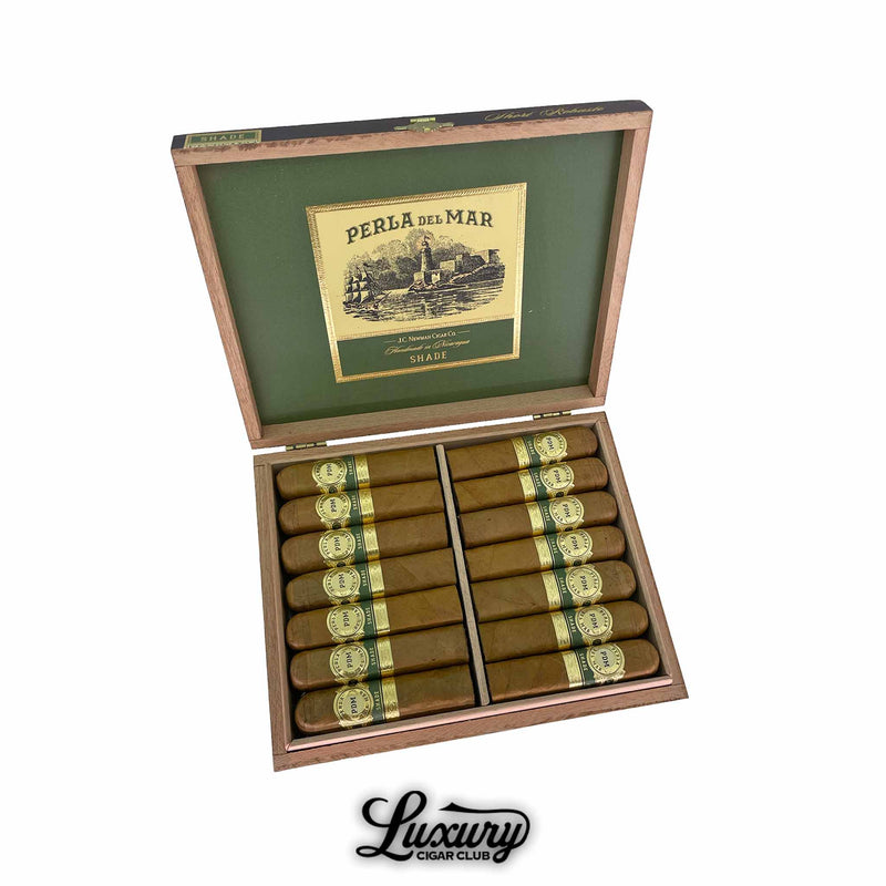 Open wooden box of Perla Del Mar Shade Short Robusto cigars with green and gold interior branding, showing neatly arranged cigars featuring golden bands with “PDM” and “Shade” text. Luxury Cigar Club logo displayed below.