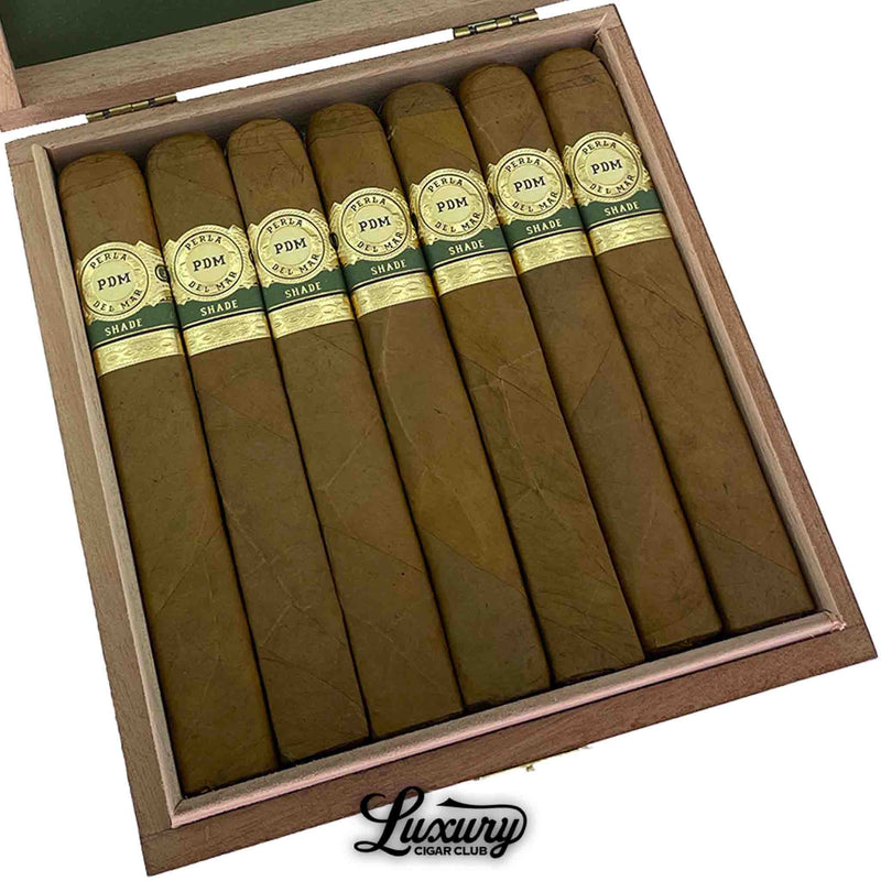 Close-up of Perla Del Mar Shade Toro cigars in open wooden box showing the smooth Connecticut shade wrappers and elegant gold bands labeled “PDM Shade.” Luxury Cigar Club logo visible.