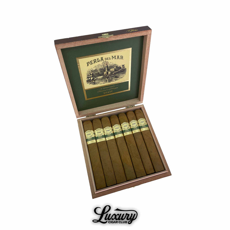 Open box of Perla Del Mar Shade Toro cigars with light brown wrappers, golden cigar bands, and interior green and gold Perla Del Mar branding. Luxury Cigar Club logo featured below.