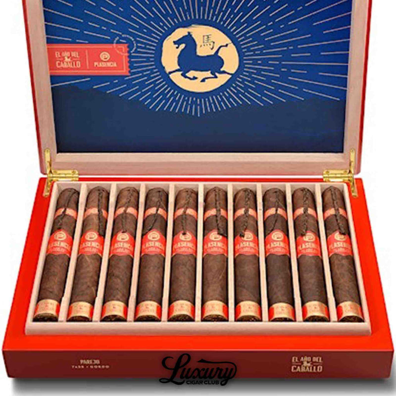 Close-up of Plasencia El Año del Caballo Parejo Gordo cigars in a red collector’s box. The bold blue interior with a golden horse emblem contrasts with the dark Maduro wrappers and red-gold cigar bands. A vivid presentation reflecting Plasencia’s artistry and Nicaraguan heritage. Luxury Cigar Club.