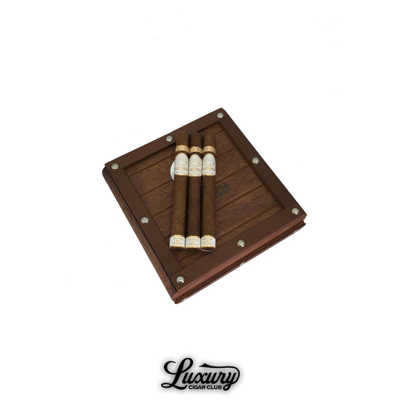 Plasencia Reserva Original Churchill cigars resting on a rustic wooden box with metal rivet accents, premium Nicaraguan cigars from Luxury Cigar Club.