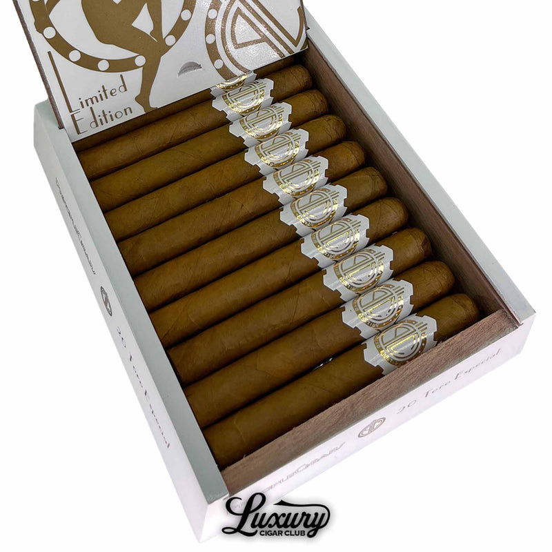 Close-up of Principle Cigars White Gold 10th Anniversary Toro showing smooth golden Connecticut wrappers and detailed gold-and-white cigar bands inside an open box. Luxury Cigar Club logo beneath.