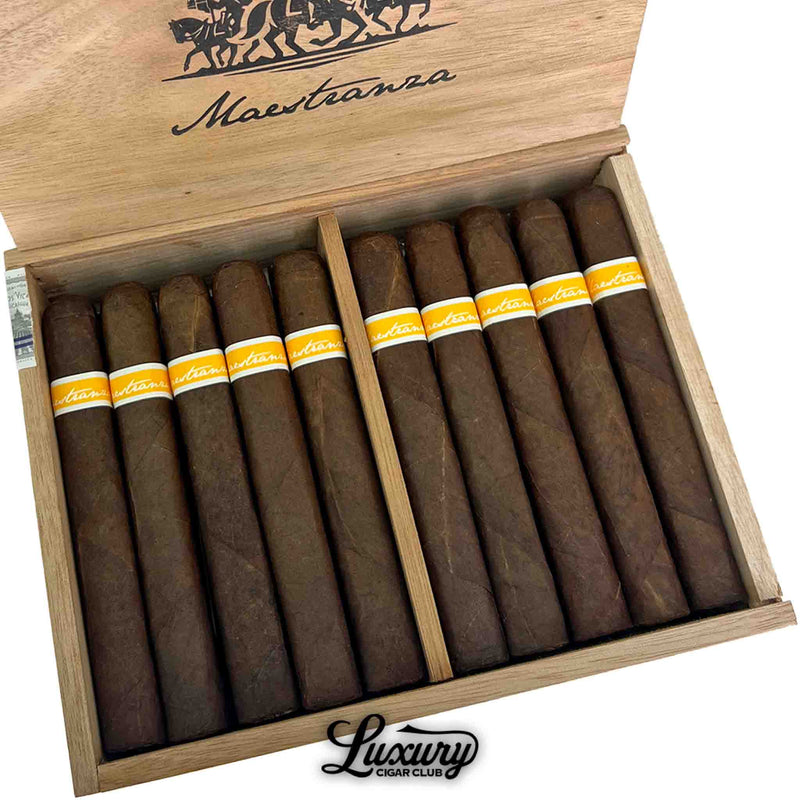 Close-up of RoMa Craft Maestranza Caballería Valencia cigars showing dark, oily wrappers and elegant yellow-and-white bands inside a rustic wooden box.