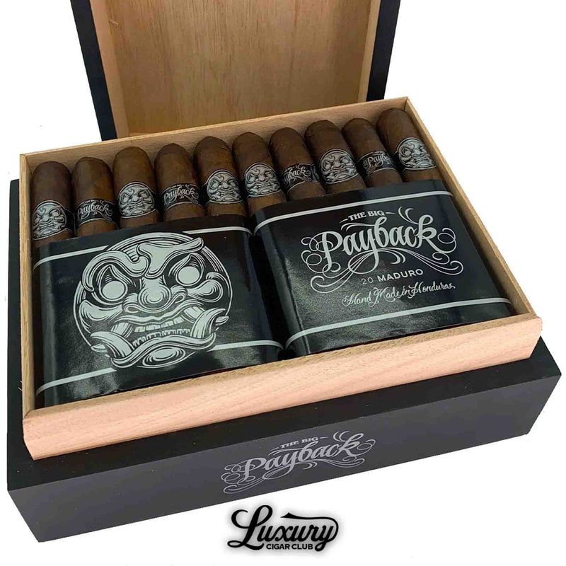 Close-up of Room101 Big Payback Maduro Toro cigars in a wooden box, showcasing dark wrappers, silver skull face bands, and bold black and silver packaging with “Hand Made in Honduras” text.