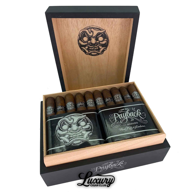 Open box of Room101 Big Payback Maduro Toro cigars featuring dark brown cigars with silver bands, a bold face logo on the inner lid, and “Luxury Cigar Club” branding below.