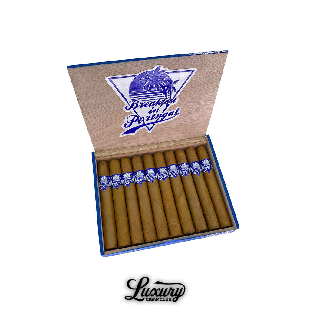 Open cedar box of Room 101 Breakfast in Portugal Toro cigars with blue and white branding and palm tree logo on the lid.