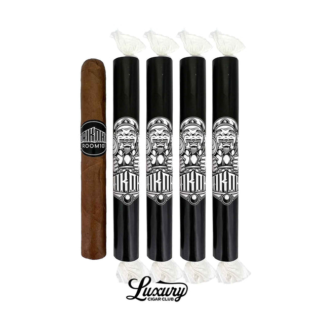 One unwrapped Room101 Daikoku Toro cigar with a brown wrapper and black band beside four black cigar tubes featuring white Daikoku artwork at Luxury Cigar Club.