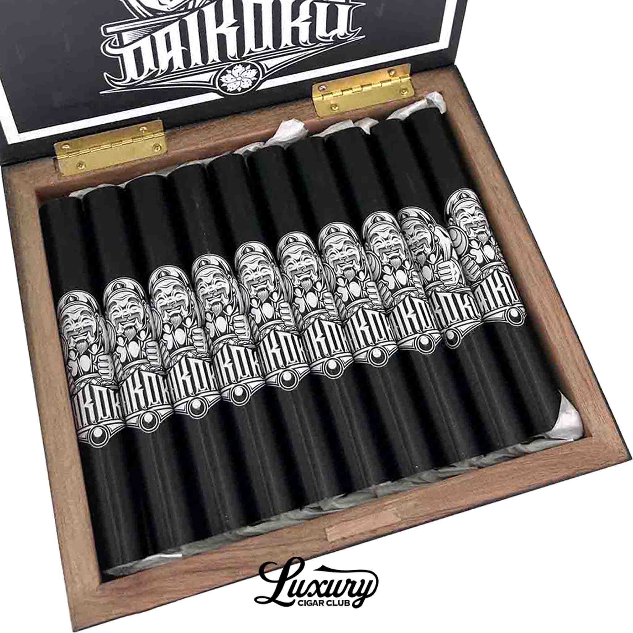Close up of Room101 Daikoku Toro cigars in black tubes with detailed white Daikoku illustrations arranged inside a wooden box at Luxury Cigar Club.