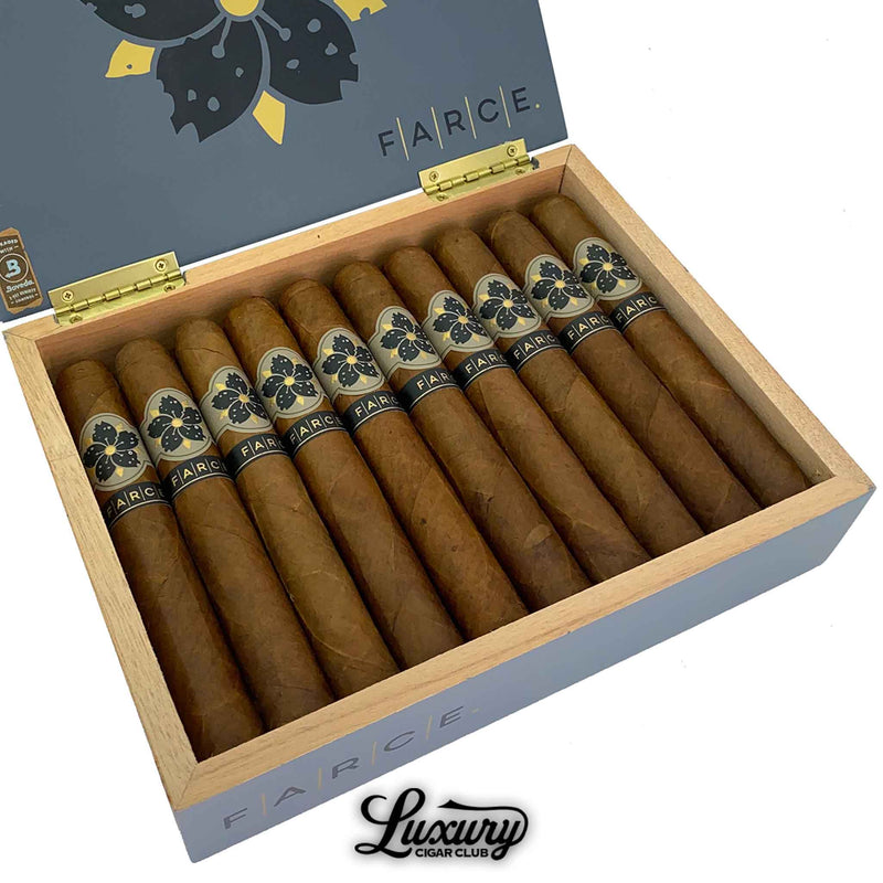 Close-up view of Room101 Farce cigars inside an open box at Luxury Cigar Club, highlighting golden brown wrappers and elegant black and gold cigar bands.