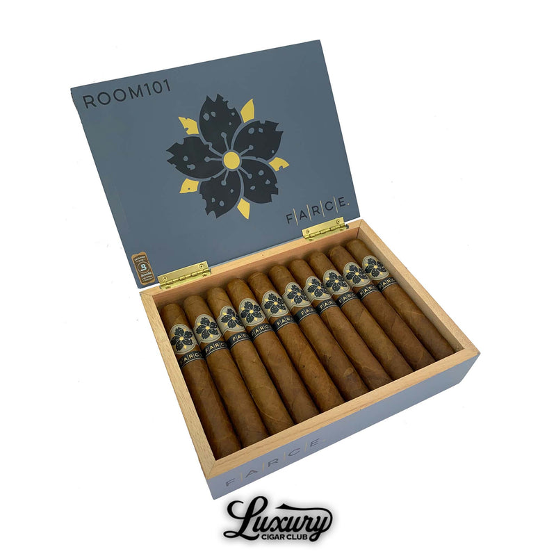 Open box of Room101 Farce cigars displayed at Luxury Cigar Club, featuring a grey lid with floral logo and neatly arranged premium handmade cigars.