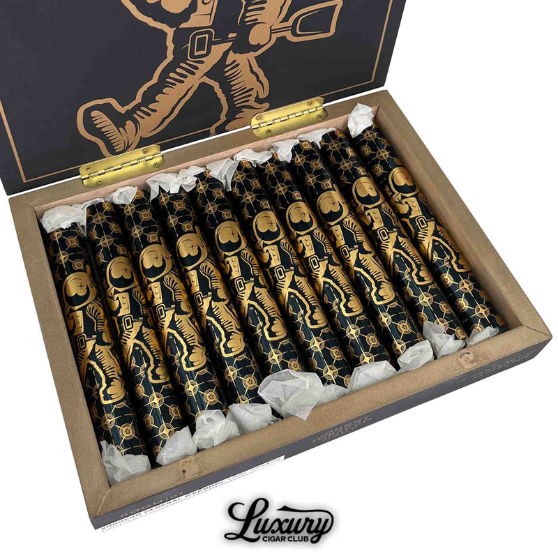 Close-up of Room101 Johnny Tobacconaut Ranflactic Perfecto cigars, each encased in striking black and gold foil with astronaut graphics. Cigars are arranged neatly in an open box with white tissue wrapping at the foot, under a lid featuring matching gold astronaut artwork. Luxury Cigar Club logo below.