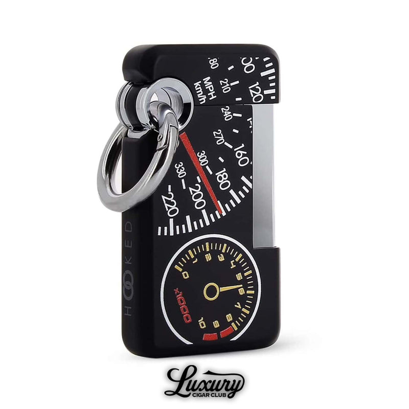 Modern ST Dupont Hooked single jet lighter with racing-inspired speedometer and tachometer artwork, black lacquer finish with chrome accents, durable and collectible, sold by Luxury Cigar Club.