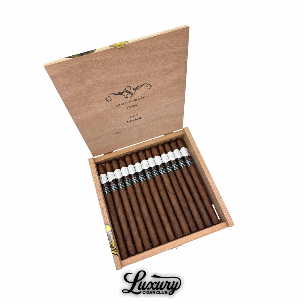 Open box of Sencillo Black Limited Edition Lancero cigars arranged in two neat rows with elegant black and white cigar bands inside a wooden box with Luxury Cigar Club branding