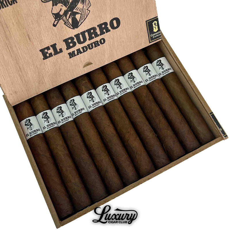 Close-up of Sinistro El Burro Maduro Toro cigars in an open box, showing dark, rich wrappers and white bands with the El Burro logo. The rustic wooden lid is stamped with “El Burro Maduro” and “La Fabrica.” Luxury Cigar Club logo below.