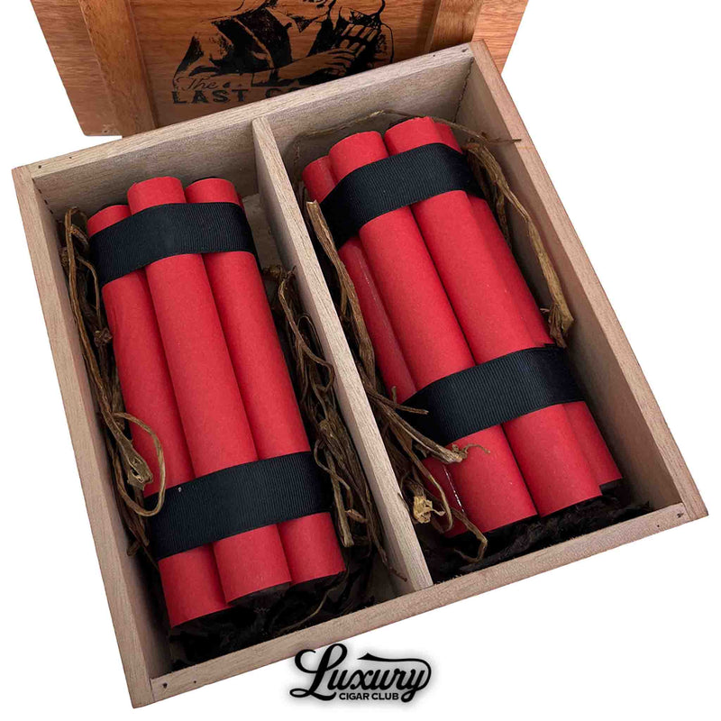 Close-up of Sinistro's "The Last Cowboy 2025 Limited Edition" cigars, showcasing two neat bundles of red-wrapped cigars tied with black ribbon, nestled in rustic tobacco leaf packing inside a wooden display box.