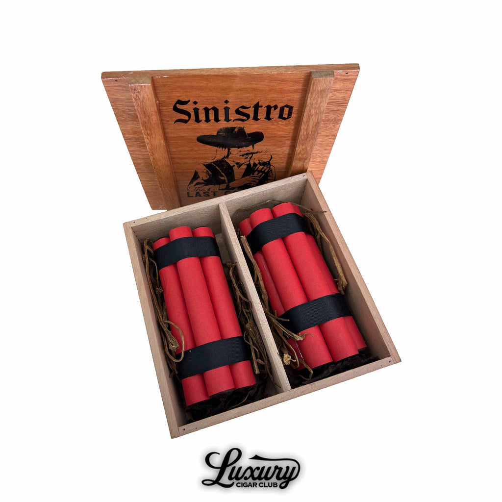 Open wooden cigar box featuring Sinistro's "The Last Cowboy 2025 Limited Edition" cigars, with bright red-wrapped cigars bundled in black ribbon, arranged in two compartments, and branded with a western outlaw illustration on the lid.