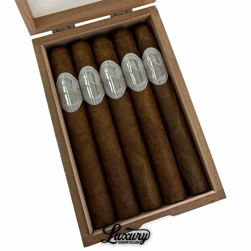 Close-up of Sinistro Mr. White Presidente Cigars in an open wooden box, showcasing five cigars with elegant silver bands featuring the Sinistro logo. Box interior has a clean, minimalist design with the Luxury Cigar Club logo below.