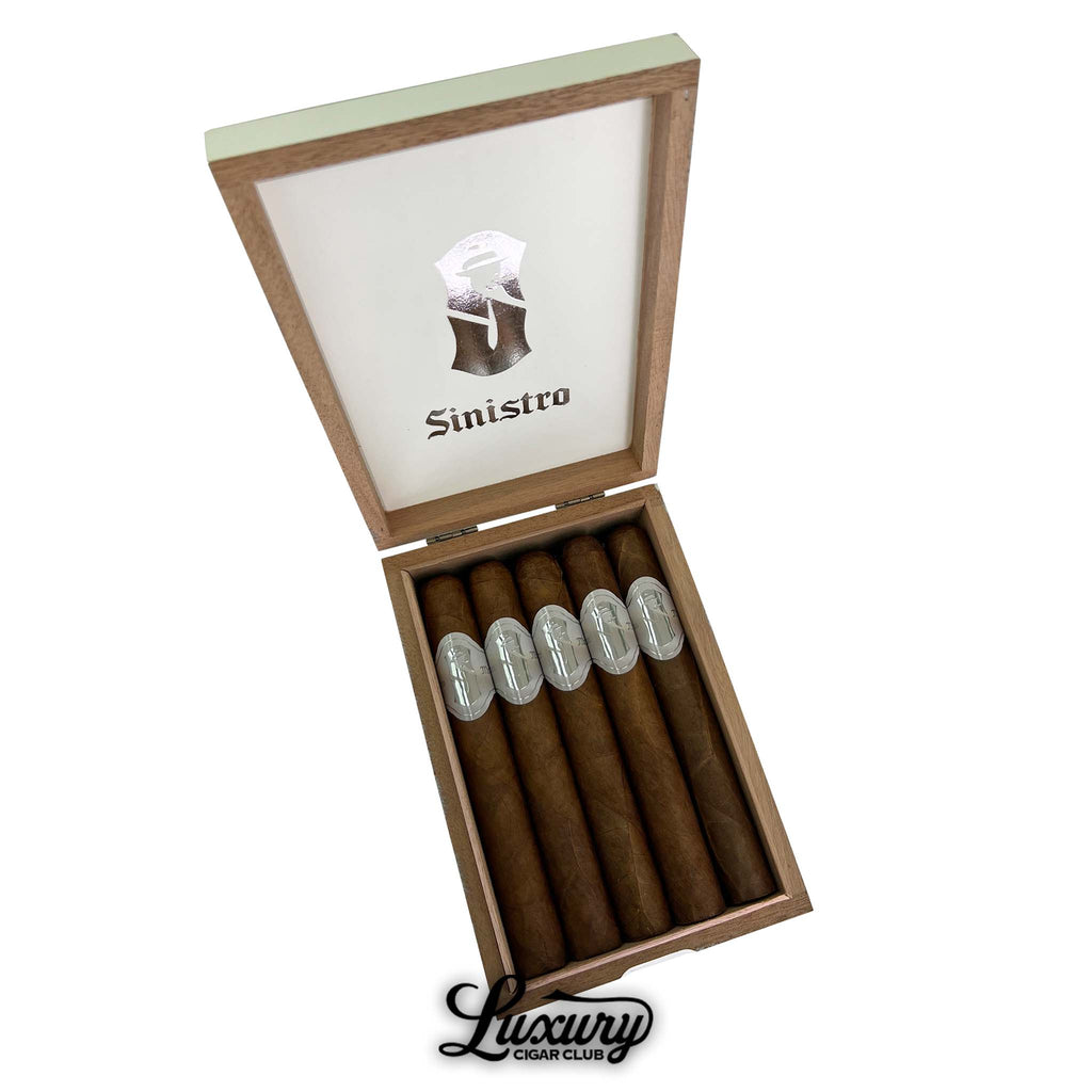 Open box of Sinistro Mr. White Presidente Cigars featuring five large-format cigars with sleek silver and white bands. The box lid displays the Sinistro logo and branding in metallic foil. Presented by Luxury Cigar Club.