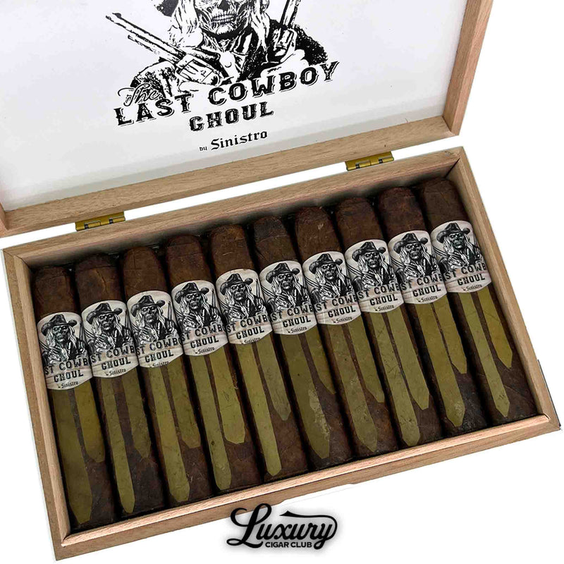 Detailed close-up of Sinistro The Last Cowboy Ghoul Toro cigars inside a wooden box with skull cowboy artwork and dual-tone wrappers. Luxury Cigar Club logo underneath.