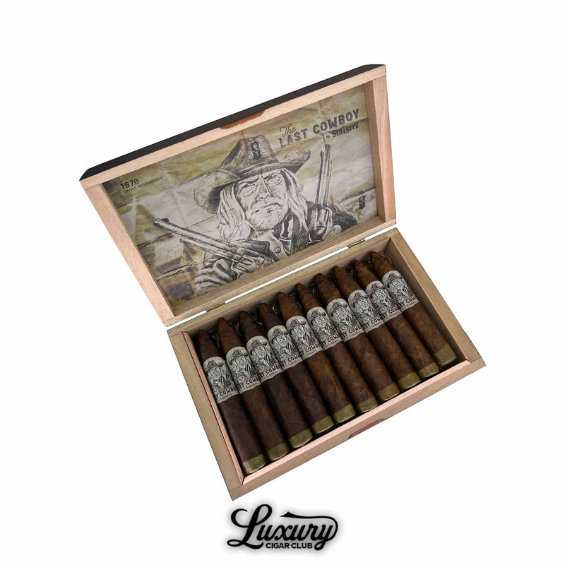 Open wooden cigar box containing twelve Sinistro The Last Cowboy Maduro Petite Belicoso cigars, each with a closed foot and a sharply tapered head. The bands feature intricate black-and-white cowboy artwork. The inside lid displays sepia-toned artwork of a cowboy with pistols and the text “The Last Cowboy by Sinistro.” The Luxury Cigar Club logo is shown below the box.