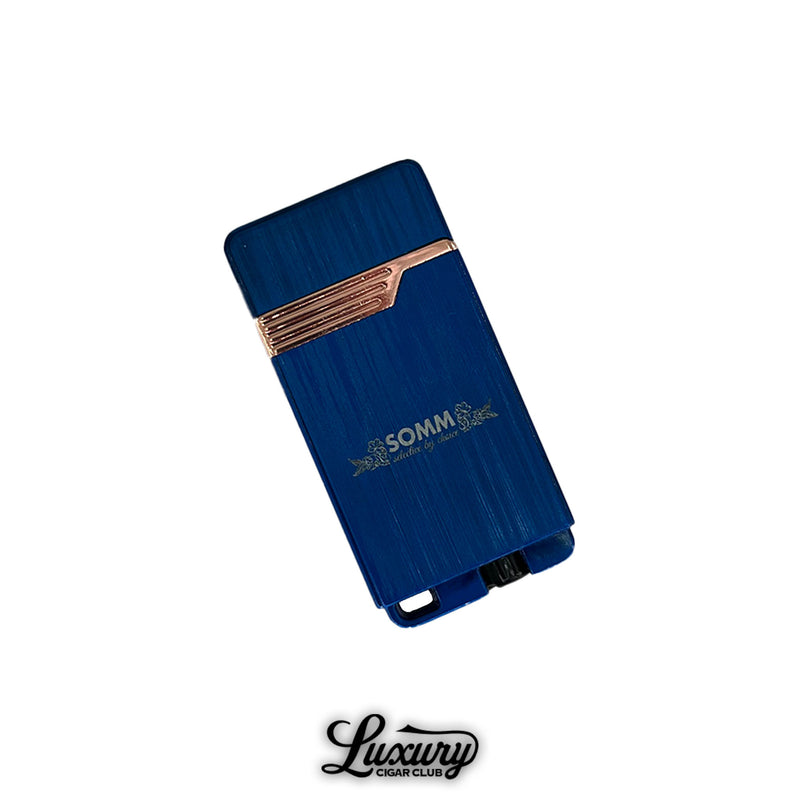 SOMM Hybrid Lighter in blue with rose gold trim, back view showing brushed metal finish and engraved SOMM branding, positioned on a clean white background with Luxury Cigar Club logo.