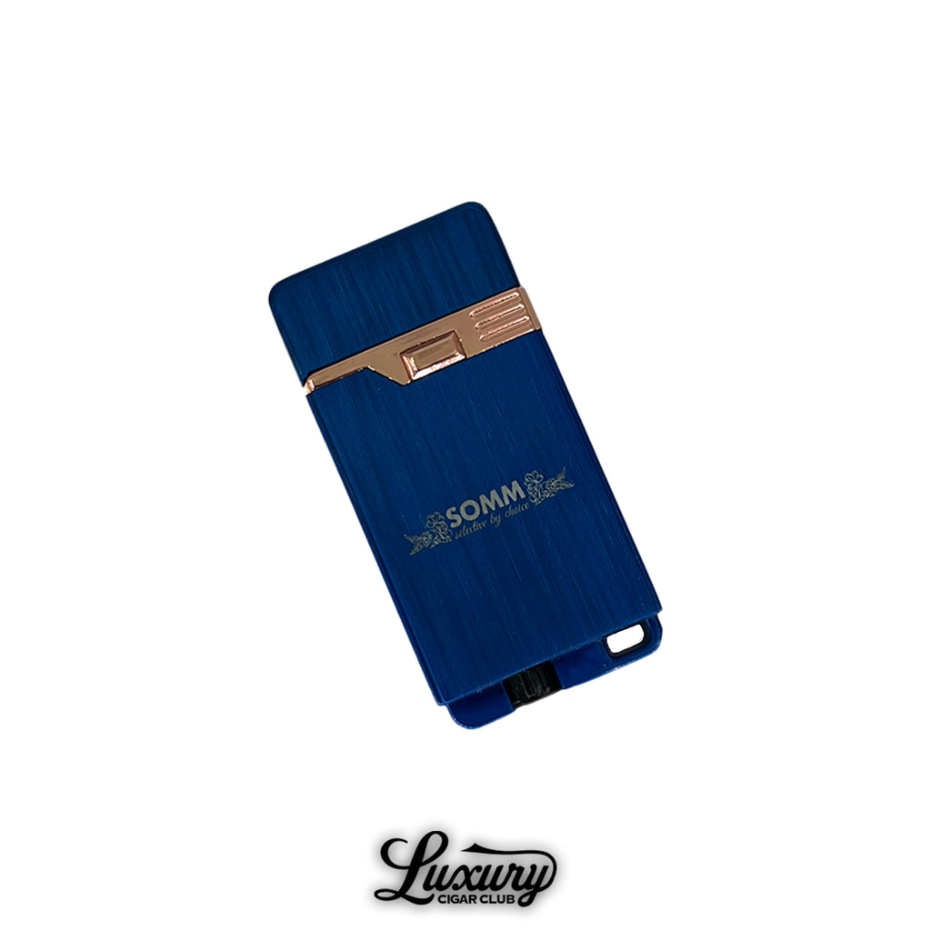 SOMM Hybrid Lighter in blue with rose gold accents, front view, featuring engraved SOMM logo and sleek rectangular design, displayed on a white background with Luxury Cigar Club logo.