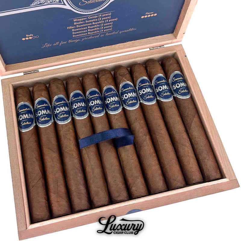 Close up of Somm Rioja Toro cigars in an open wooden box, highlighting blue SOMM bands, Corojo wrapper, and Dominican long filler blend from Luxury Cigar Club.