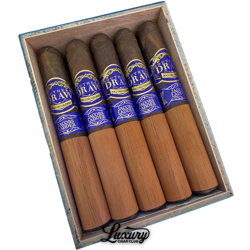 Close up view of Southern Draw Jacobs Ladder Gordo cigars inside the box, showing rich dark wrappers, blue and gold branding, and cedar sheaths.