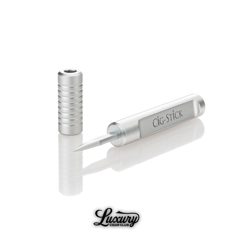 Open Stick the Stick Cig Stick showing pointed cigar tool and removable cap on reflective surface Luxury Cigar Club