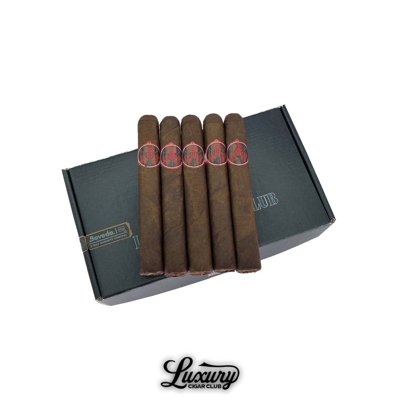 Five Stolen Throne 3 Kingdoms Toro cigars from Luxury Cigar Club displayed on a dark gray presentation box with Boveda humidity pack, featuring rich brown wrappers and red-and-black cigar bands.